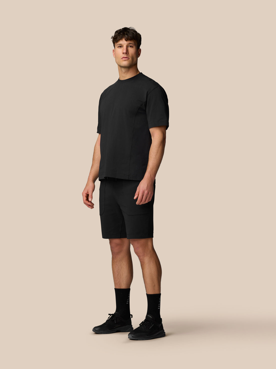 Male model wearing black Travel T Shirt with crew neck and relaxed fit