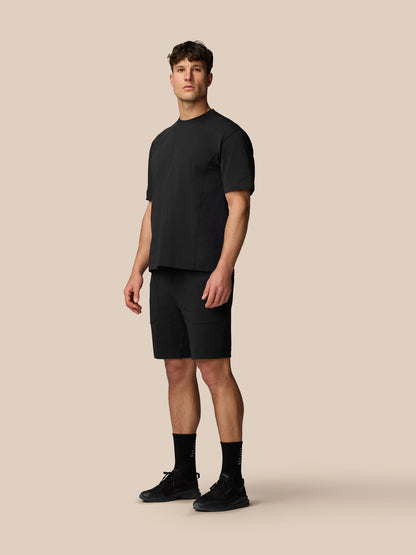 Male model wearing black Travel T Shirt with crew neck and relaxed fit