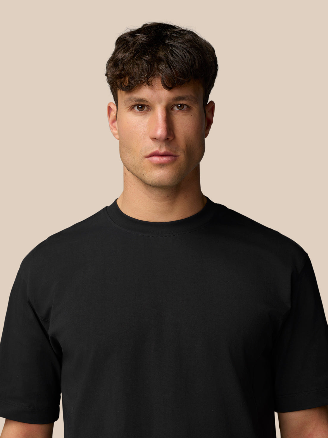 Front portrait of a man wearing a black Travel T Shirt with crew neck and short sleeves