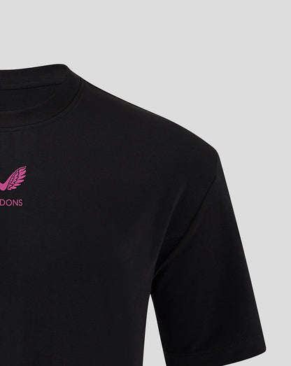 Close up of the upper chest on a black Mk Dons Travel T Shirt with pink logo and MK DONS lettering