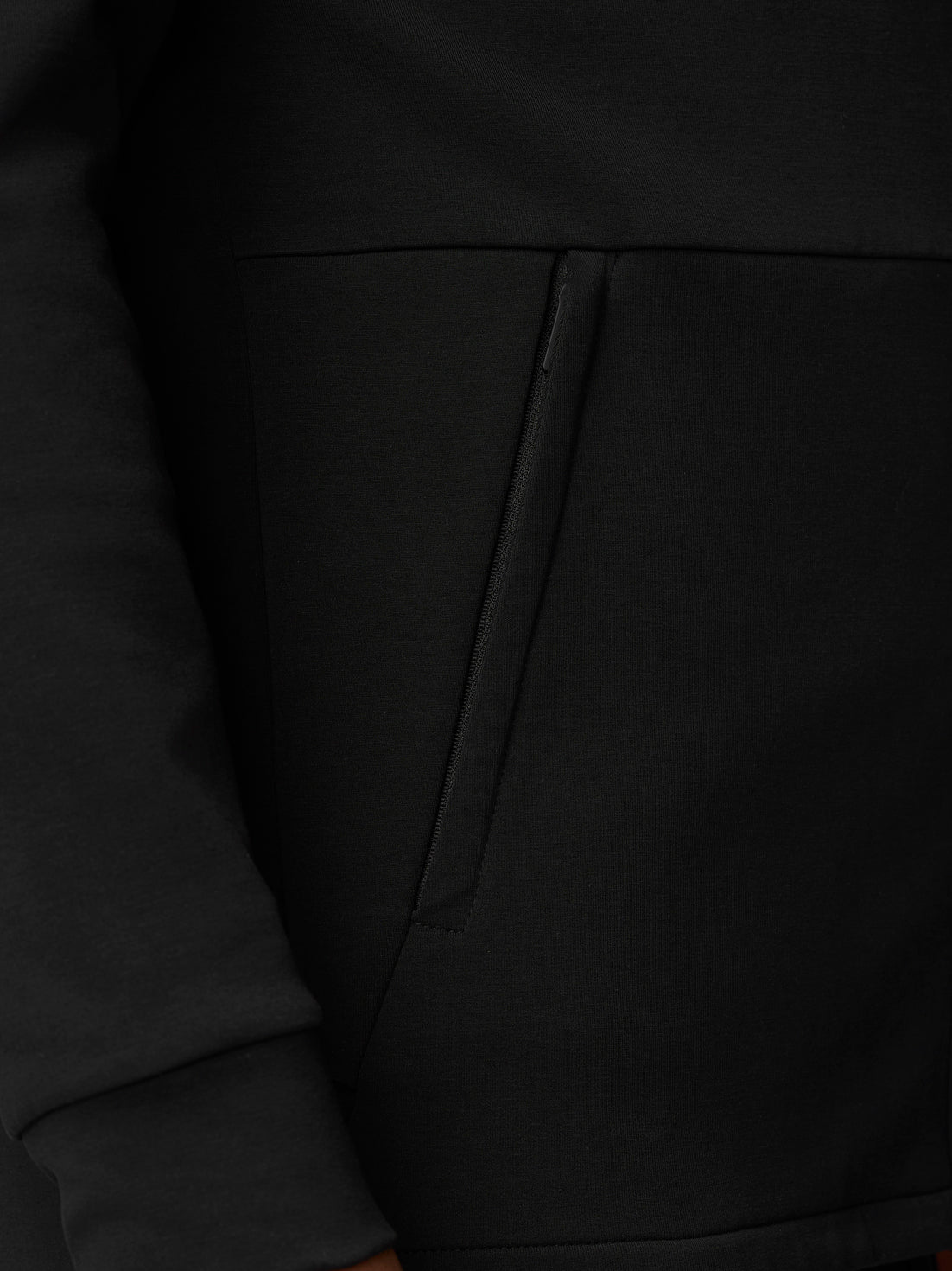 Close-up of a black Travel Full Zip Hoodie pocket with diagonal zipper detail