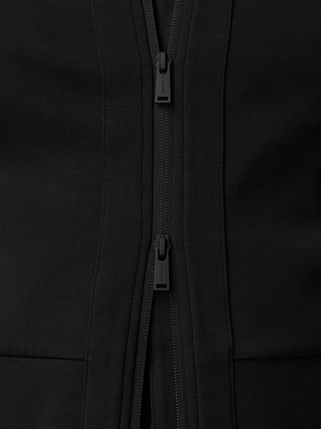 Close-up of the black travel full zip hoodie showing dual zippers and textured fabric.