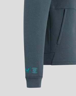 Close up of the sleeve cuff on the blue Preston NE travel jacket showing Castore and PNE logos.