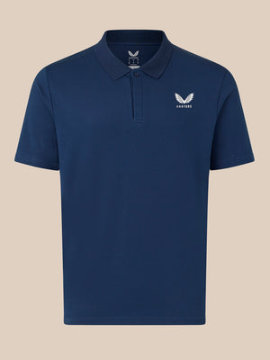 Navy Castore polo shirt front view with white wing logo on left chest on beige background
