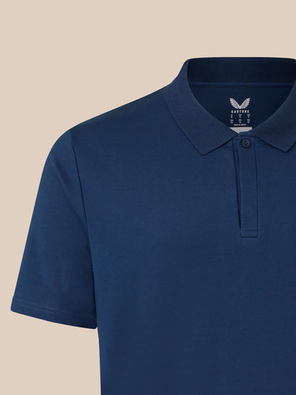 Close up of navy polo shirt showing ribbed collar and placket with embroidered crest on the chest.