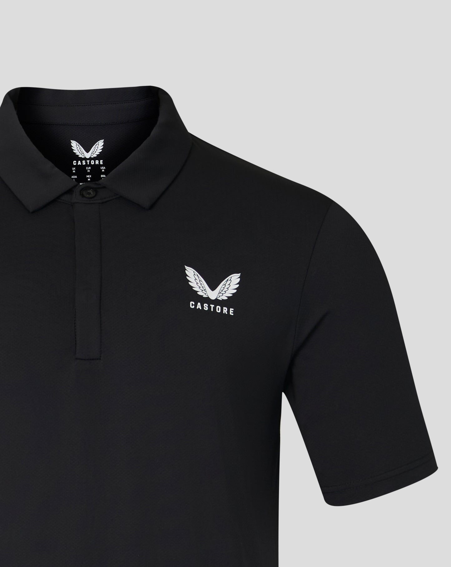Black Castore polo close up showing ribbed collar and wing logo on chest