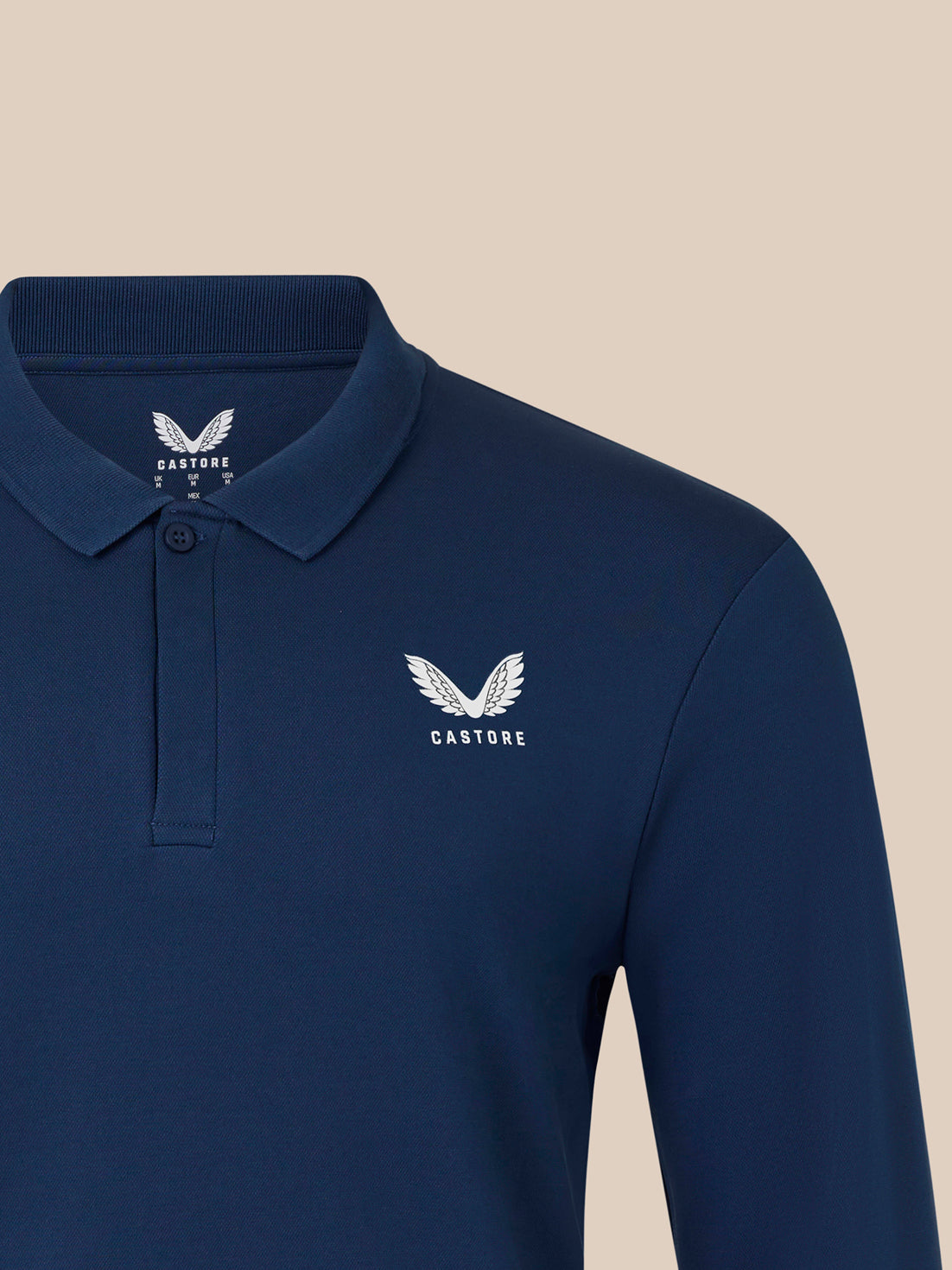 Navy polo front with white Castore crest on left chest and ribbed collar