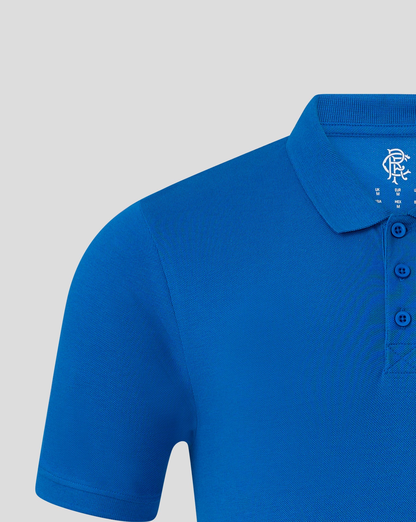 Close-up of blue Rangers FC polo chest showing crest on left and visible button placket.