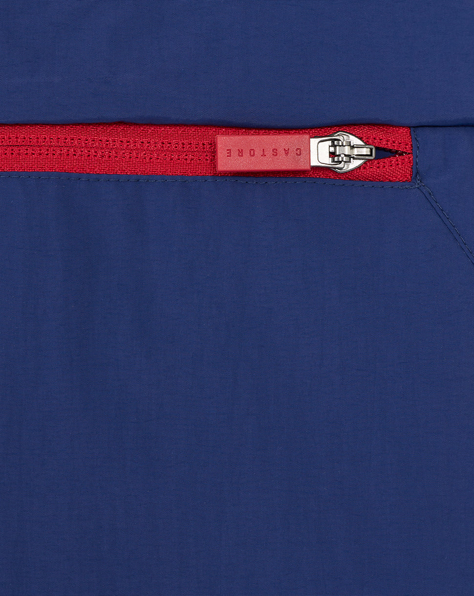 Close up of a red zipper on navy Rangers men's anorak fabric.