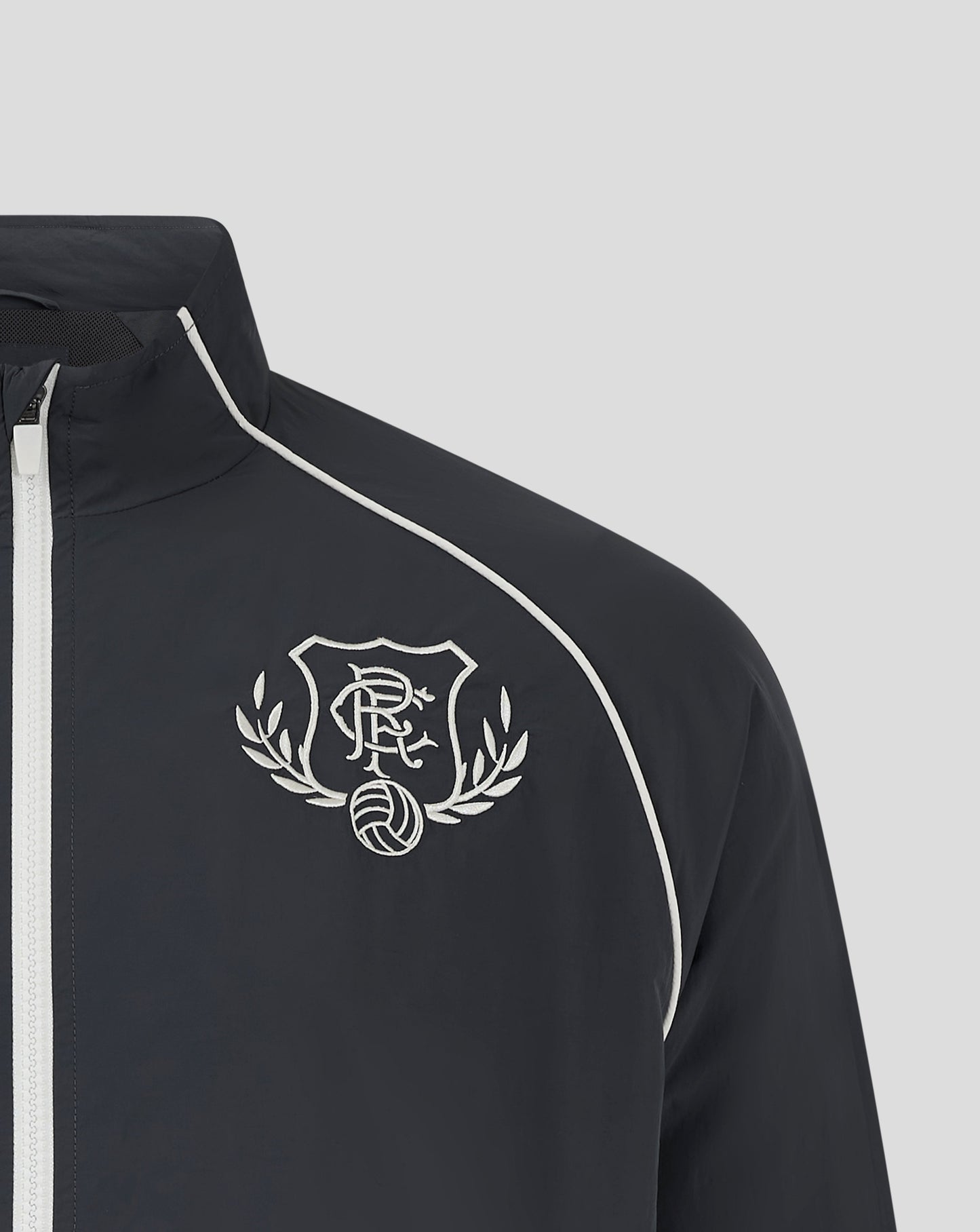 Close up of navy Rangers Track Jacket showing the embroidered crest on the chest and white piping along the shoulder