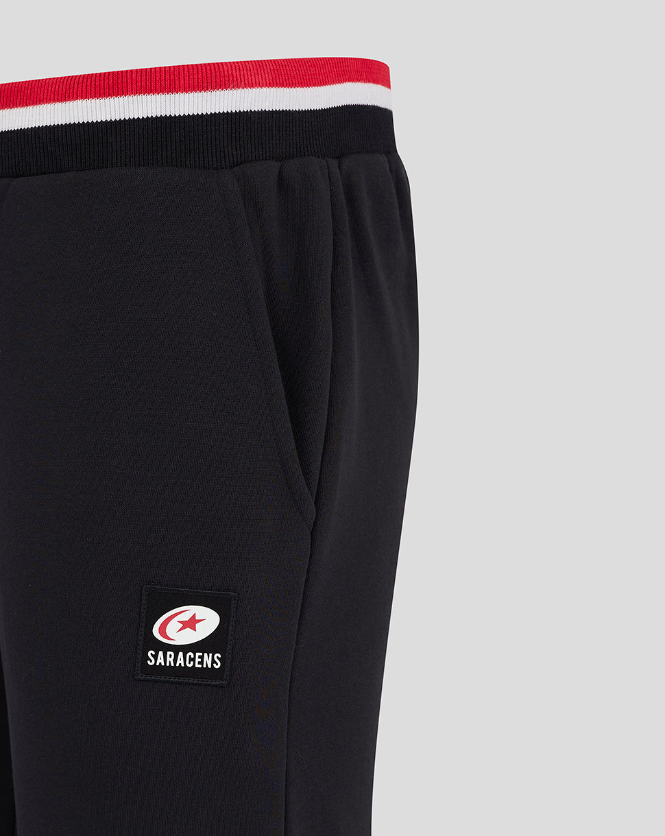 Close up of the Saracens logo patch on the leg of black joggers