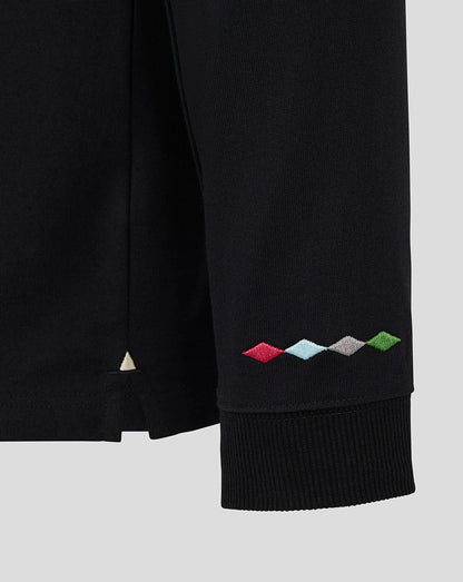 Close up of the ribbed cuff on a black Harlequins jersey sleeve with colorful diamond embroidery.