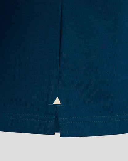 Lower hem of teal Bath Rugby jersey showing side seam split and small white triangle embroidery.