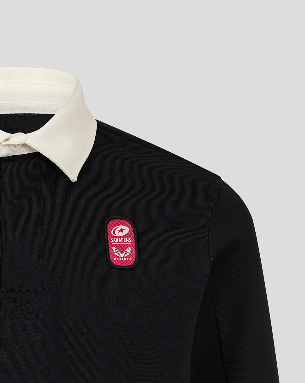 Close up of black rugby jersey chest with pink dual branded patch.