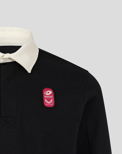 Close up of black rugby jersey chest with pink dual branded patch.