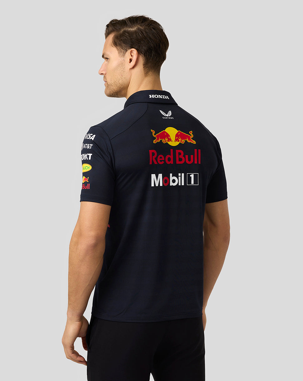 Back view of a model in a navy Red Bull Racing polo showing large Red Bull branding and sponsor decals on the back.
