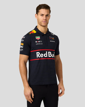 Male model wearing navy Oracle Red Bull Racing polo with large Red Bull logo across the chest and sponsor logos on the sleeves.