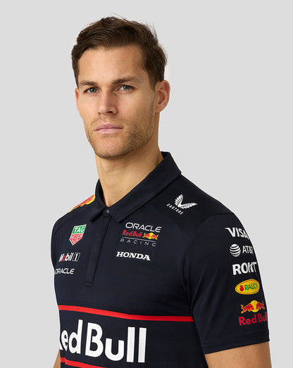 Male model wearing night sky navy Oracle Red Bull Racing polo with sponsor logos and large Red Bull branding.