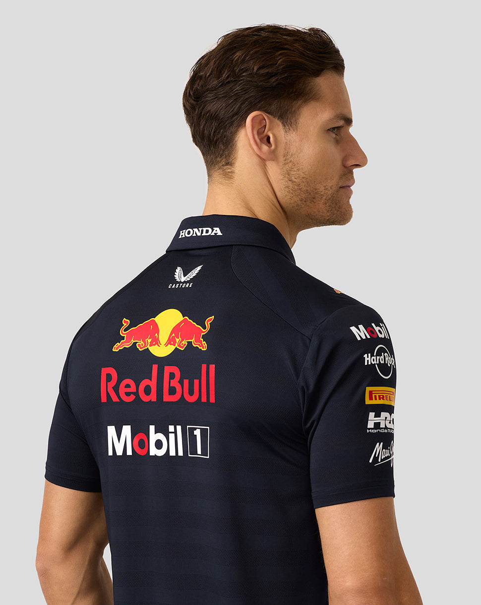 Back view of a male model in a navy Oracle Red Bull Racing polo with a large Red Bull graphic across the back.