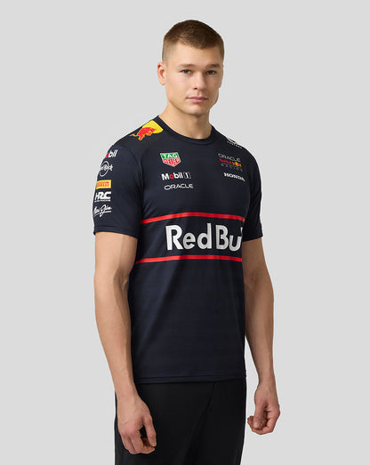 Side-front view of male model wearing navy Red Bull Set Up T-shirt with bold Red Bull crest across the chest and sponsor decals on the sleeves.
