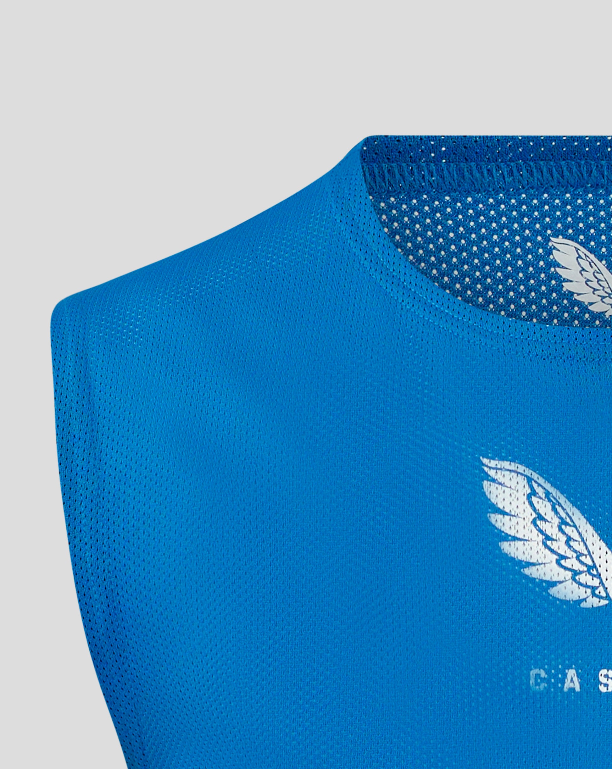 Close up of blue perforated fabric on a junior training bib with a partial white Castore logo