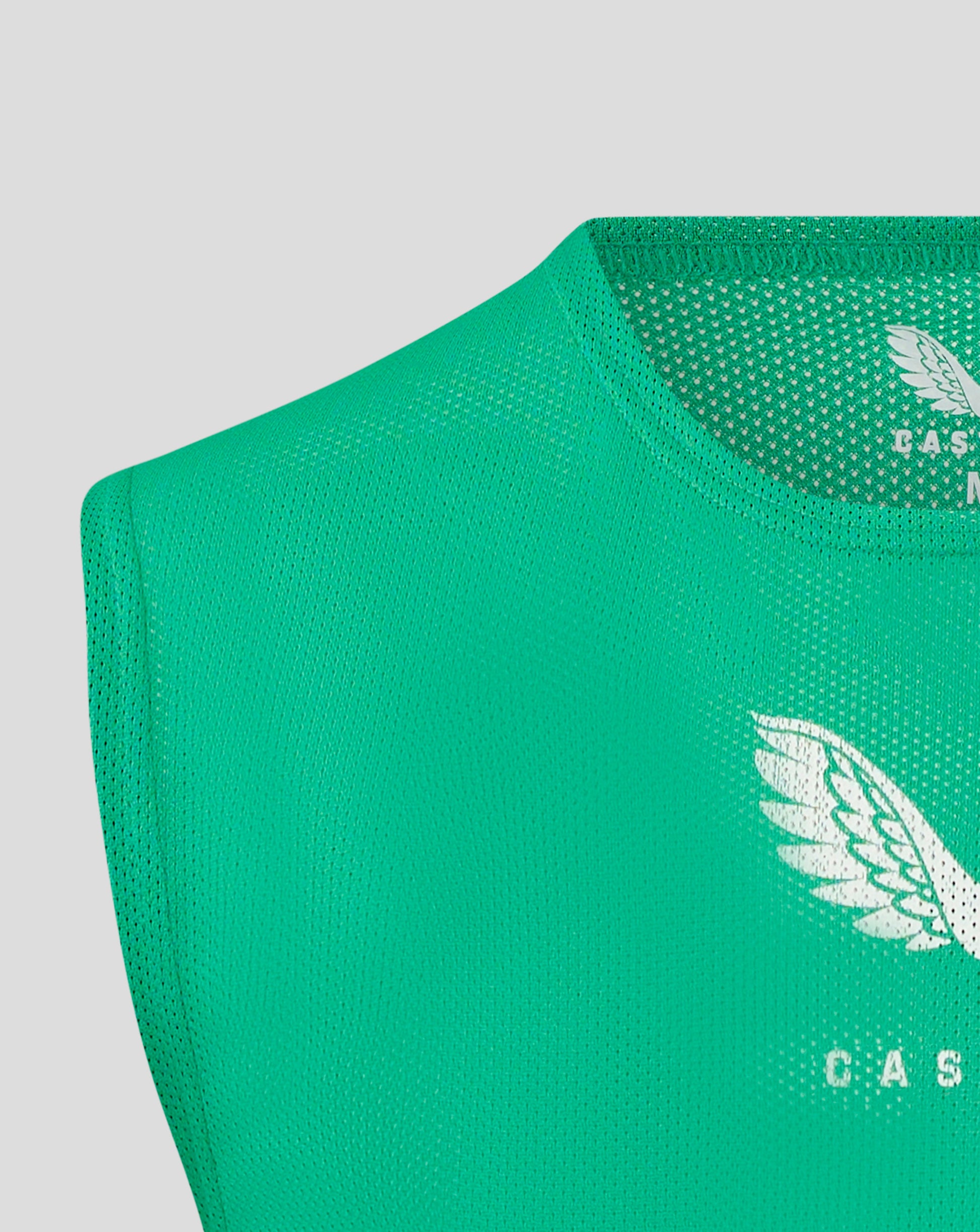 Green unisex training bib fabric close up with scoop neckline and binding at armholes