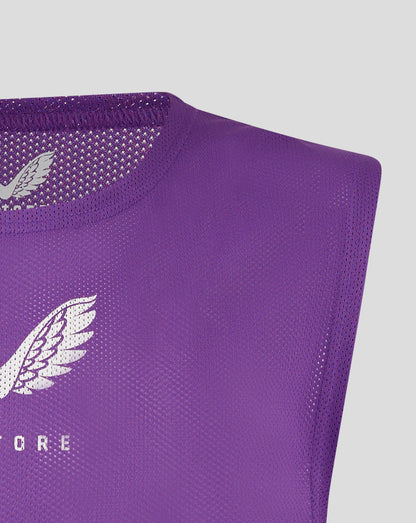 Close up of purple unisex training bib fabric with perforated texture and a printed Castore logo.