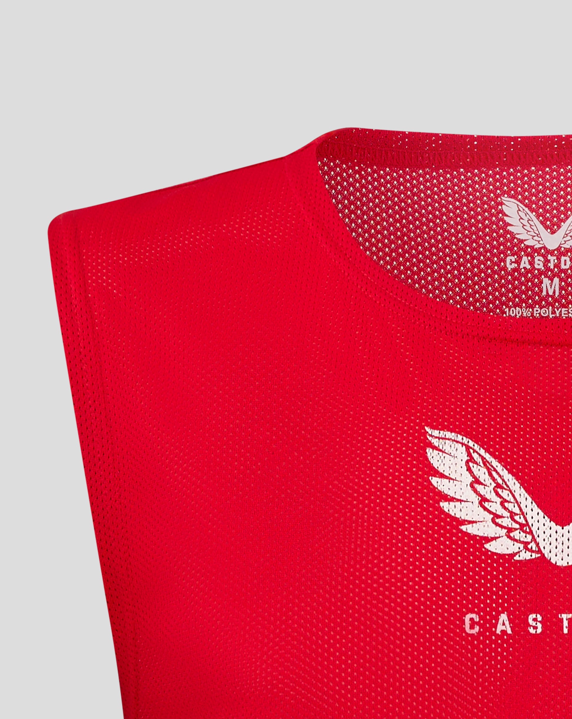 Red unisex training bib close up of the neckline and Castore logo on mesh fabric
