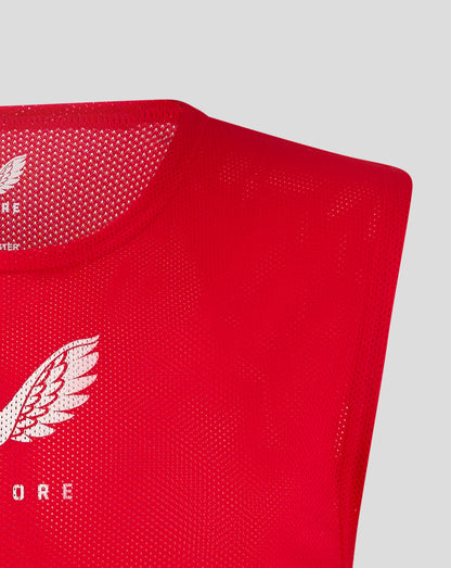 Close up of red junior training bib fabric with a partial white Castore logo