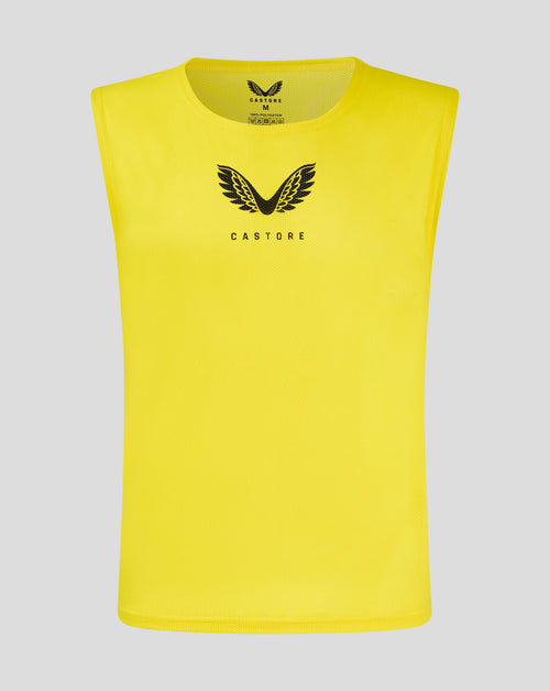Yellow junior training bib with scoop neckline and Castore logo on front