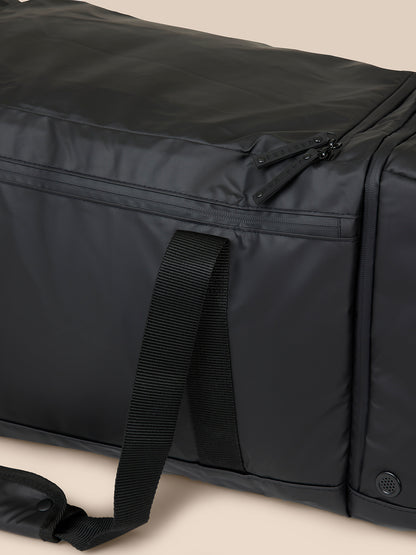 Close-up of zipper pulls labeled CASTORE on black holdall with strap detail