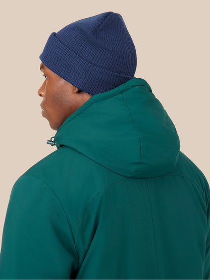 Side profile of male model in navy knit Active Beanie and teal jacket