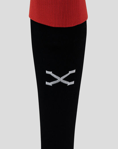 Close-up of black sock displaying a white crossbones logo on the leg