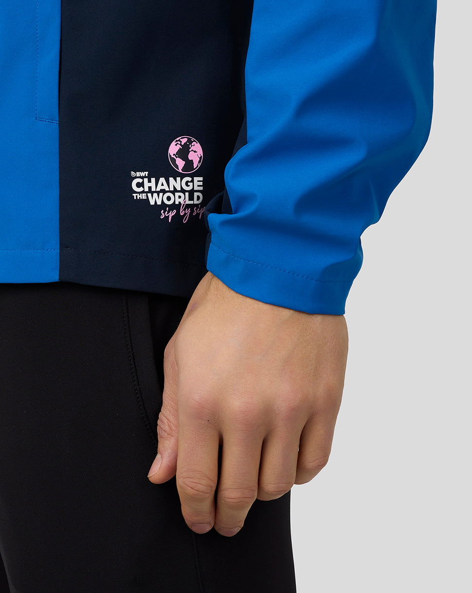 Close-up of lapis blue BWT Alpine water resistant jacket with a pink Change the World logo on a dark panel.