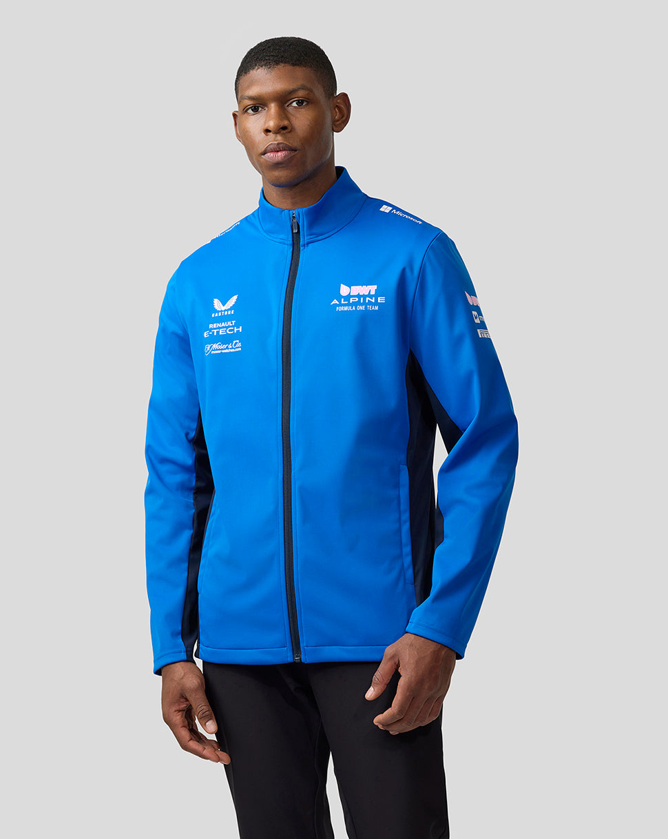 Male model wearing lapis blue BWT Alpine Formula One Team unisex soft shell jacket with front zip and side panels