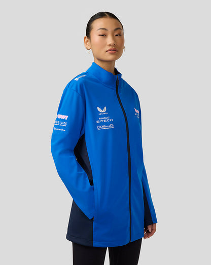 Woman wearing lapis blue BWT Alpine Formula One Team unisex soft shell jacket with full front zip and sponsor graphics.