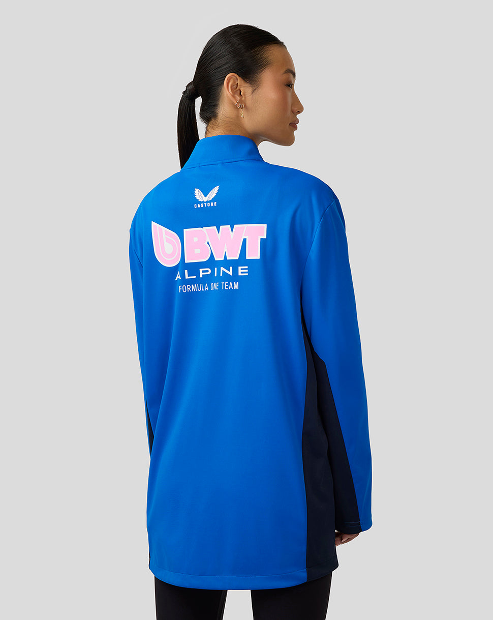 Woman seen from behind wearing blue BWT Alpine jacket with large back logo and navy side panels.