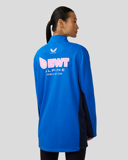 Woman seen from behind wearing blue BWT Alpine jacket with large back logo and navy side panels.