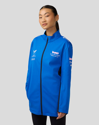 Female model wearing lapis blue BWT Alpine official unisex soft shell jacket with front zip and sponsor logos.