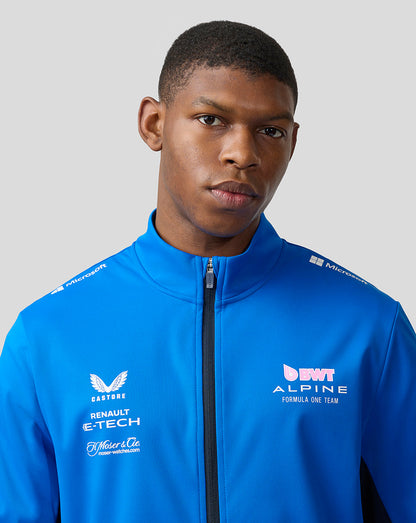 Close-up of a man in a lapis blue BWT Alpine soft shell jacket with chest sponsor logos.