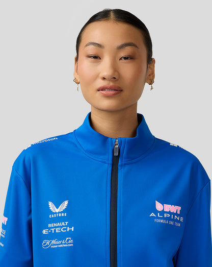 Portrait of a model in a lapis blue BWT Alpine soft shell jacket with zipper and sponsor logos.
