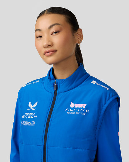 Close up of a female model in a lapis blue BWT Alpine Formula One Team hybrid gilet featuring a funnel collar and logo prints