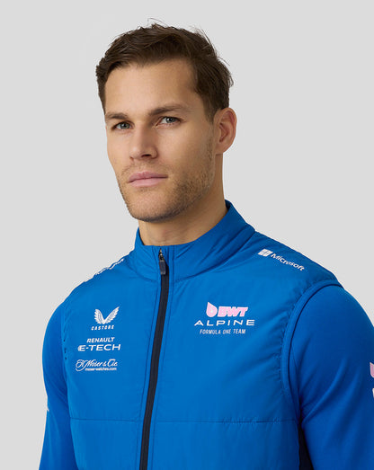 Close up of a male model wearing a lapis blue BWT Alpine Formula One Team hybrid gilet with a zipped front and logo detailing