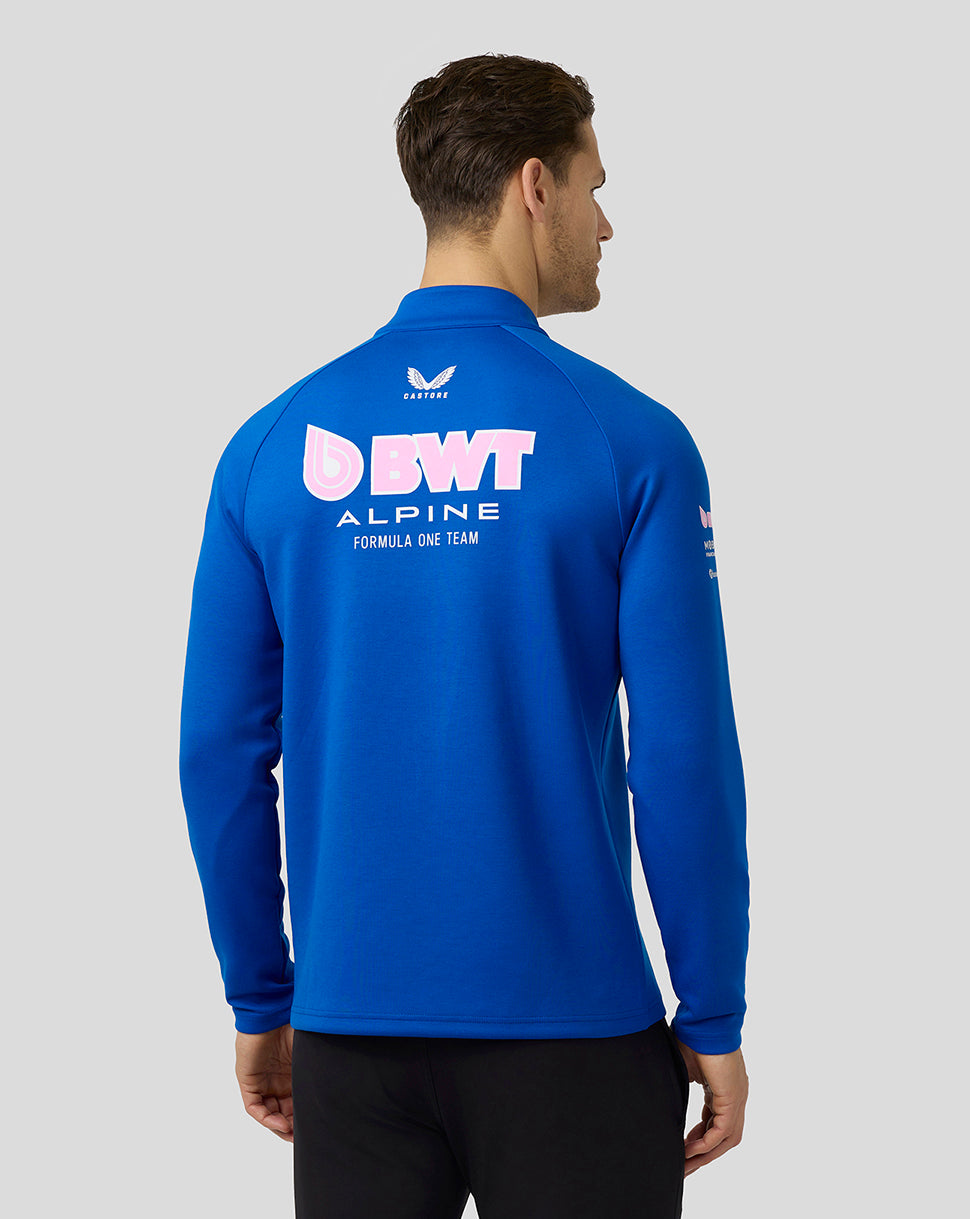 Back view of a man wearing a blue BWT Alpine Formula One Team midlayer with a large logo on the back