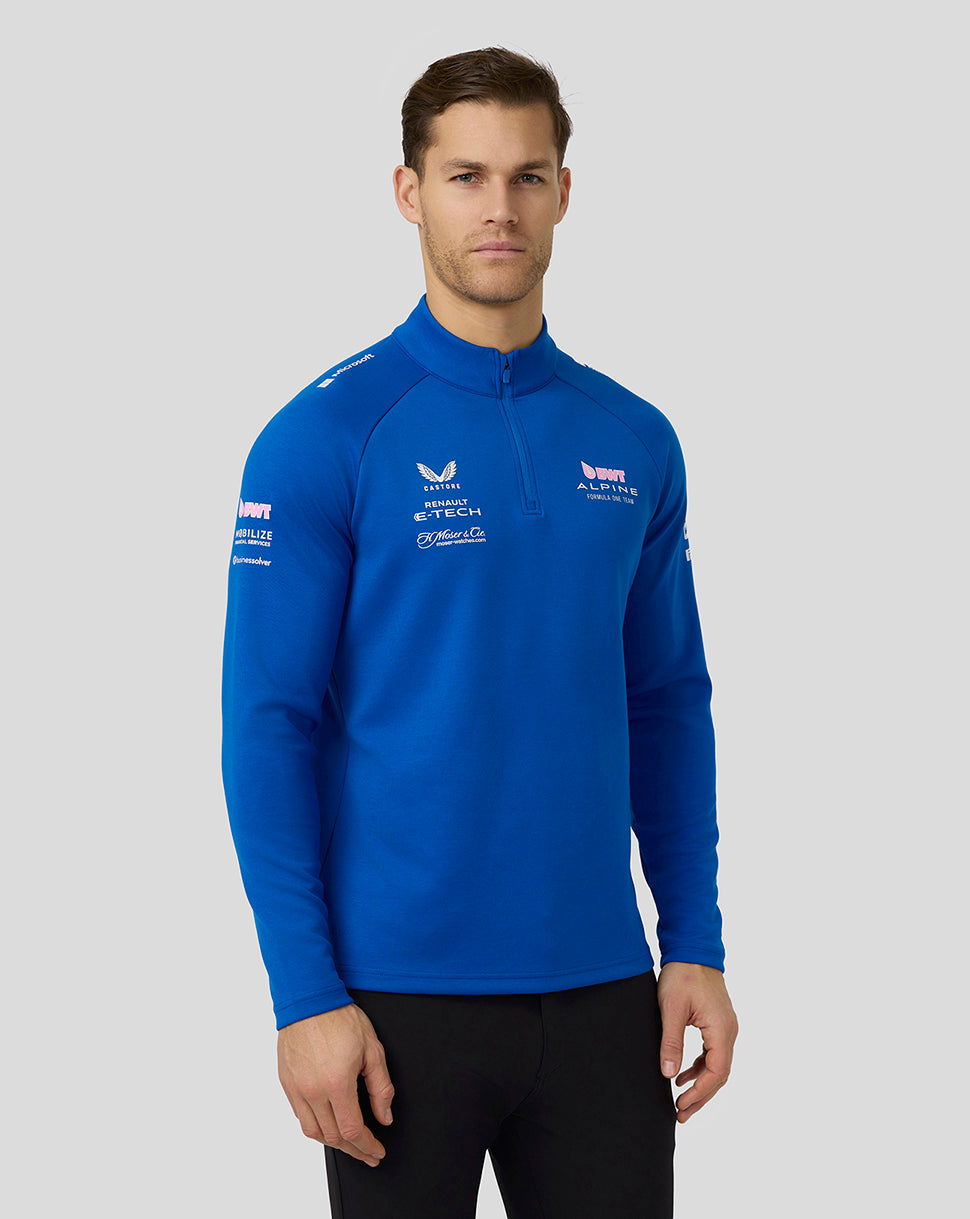 Male model wearing lapis blue BWT Alpine Formula One Team unisex quarter zip mid layer with funnel neck.