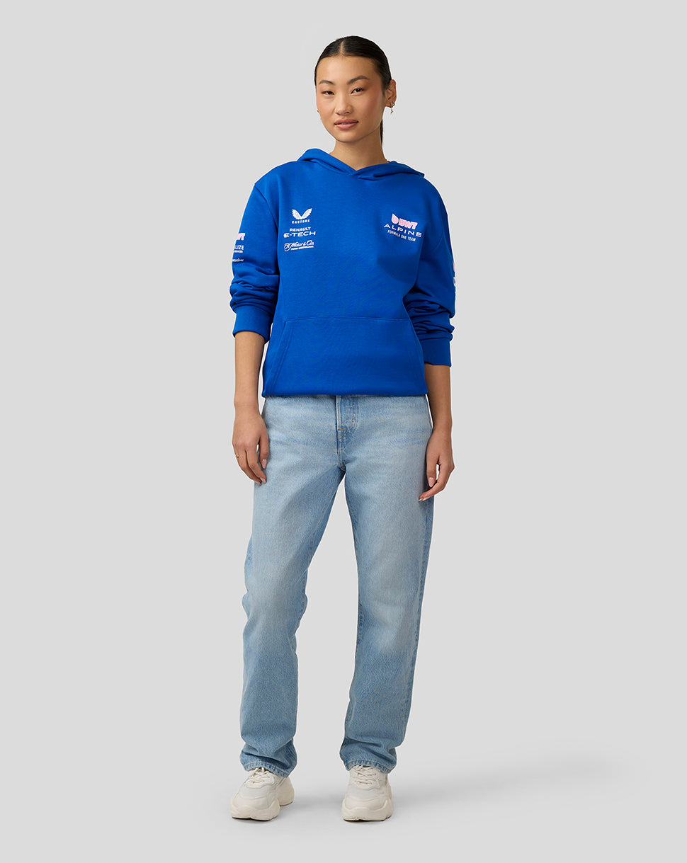 Female model in a royal blue BWT Alpine unisex pullover hoodie with chest logos, paired with jeans
