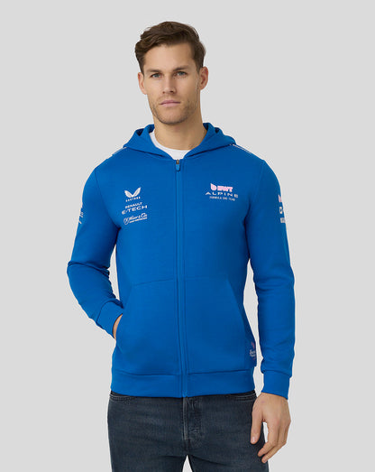 Male model wearing lapis blue BWT Alpine Formula One Team official unisex full zip hoodie with chest logos