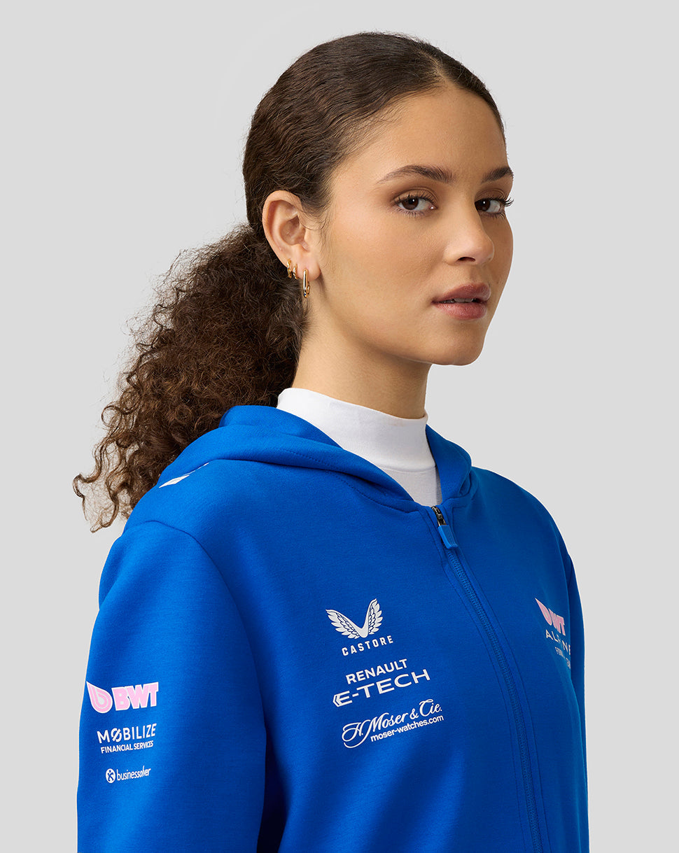 Profile view of a woman in lapis blue BWT Alpine full zip hoodie showing chest and sleeve logos