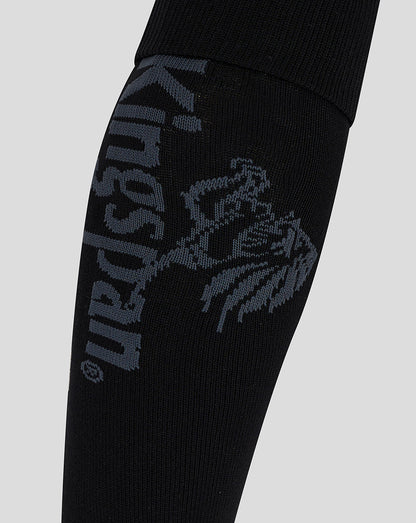 Close up of black Ulster home sock showing a blue gray crest and branding knit into the fabric.