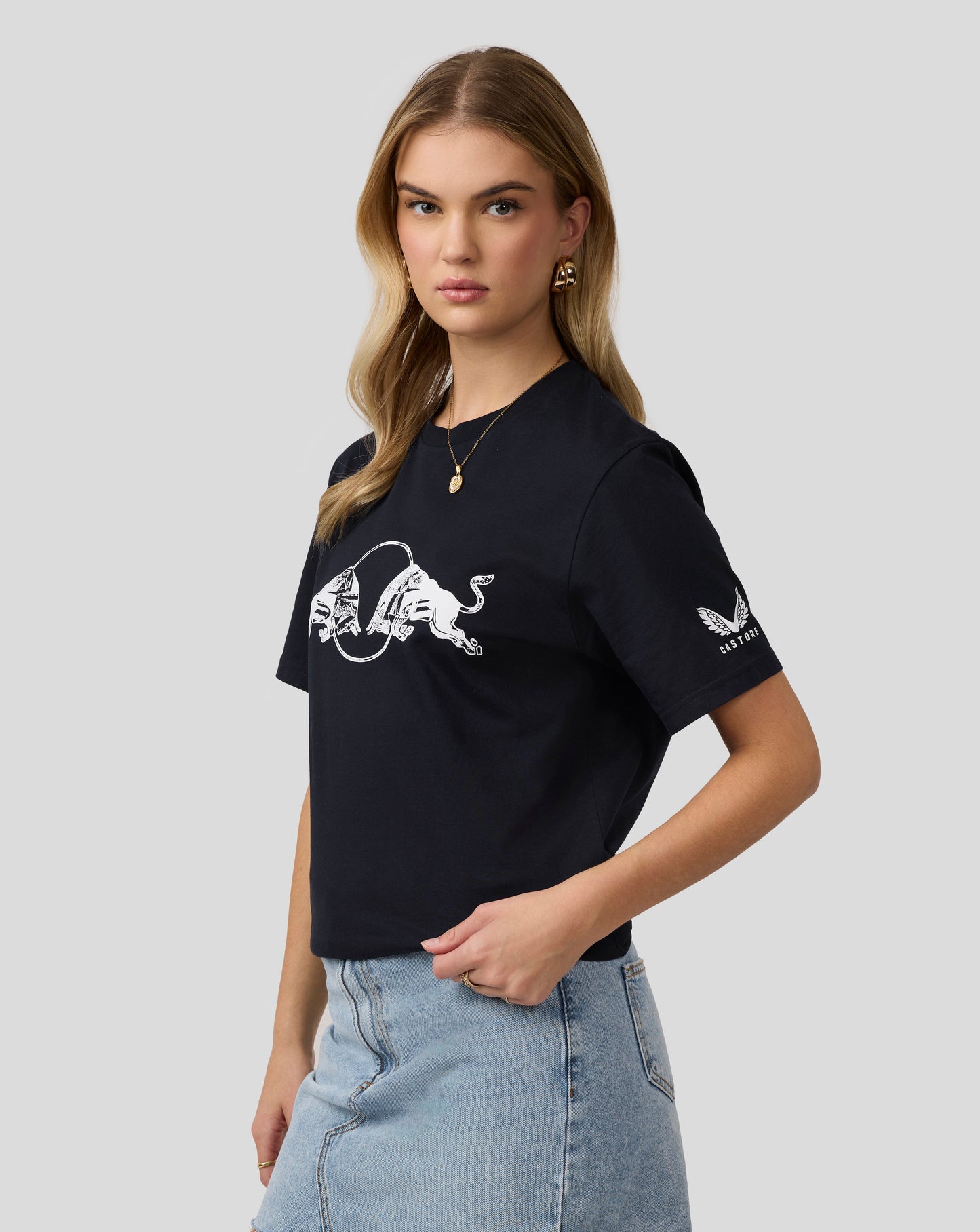 Portrait of a woman wearing a black Oracle Red Bull Racing graphic bull T shirt with a white bull design.